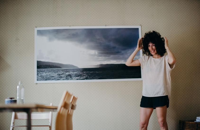 Caroline Eckly in a room with a table and a painting on the wall