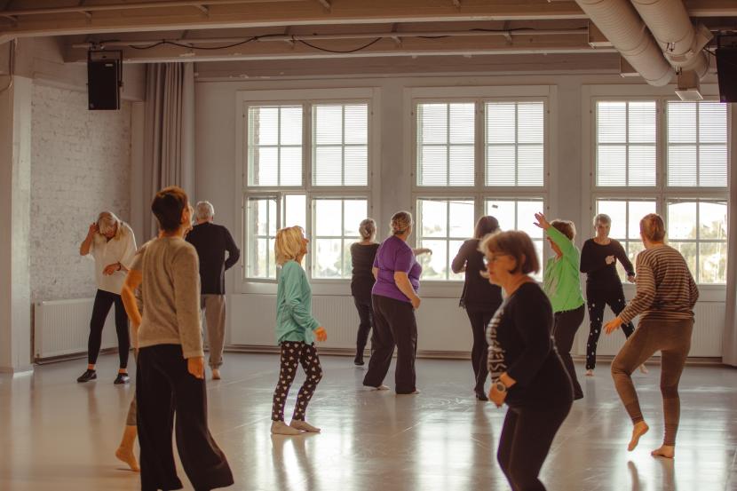 A group of seniors dancing in a white space