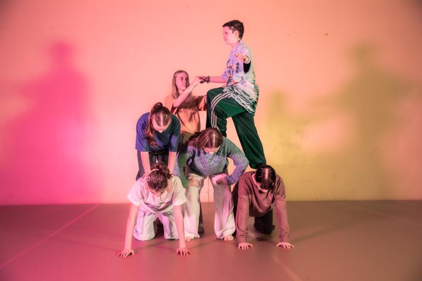 A human pyramid. The background is colourful.